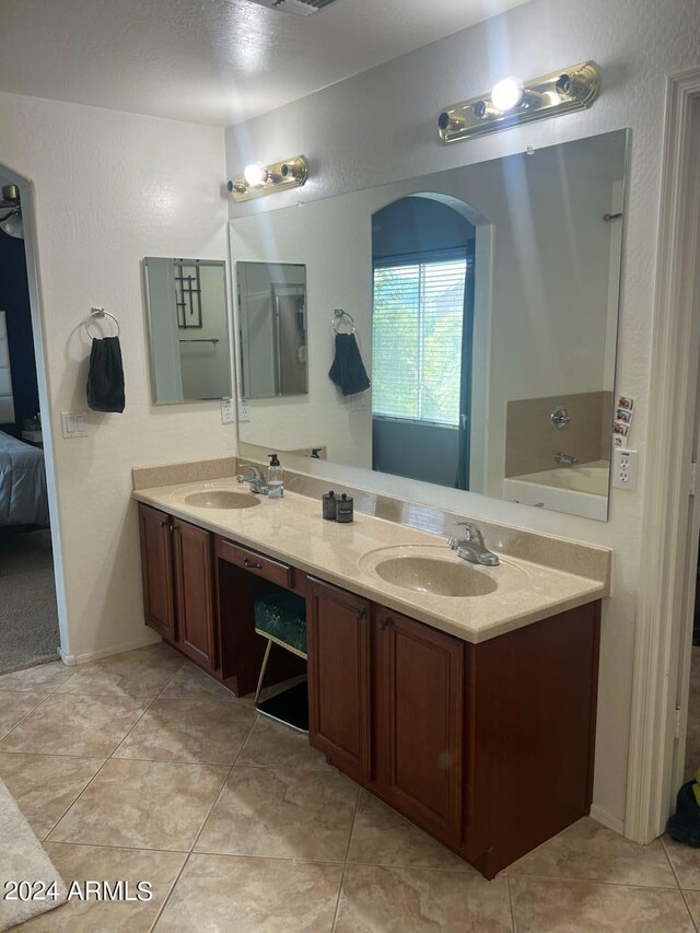 bathroom featuring tile patterned floors, a bathtub, and vanity