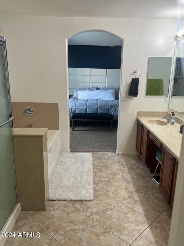 bathroom with tile patterned flooring, independent shower and bath, and vanity