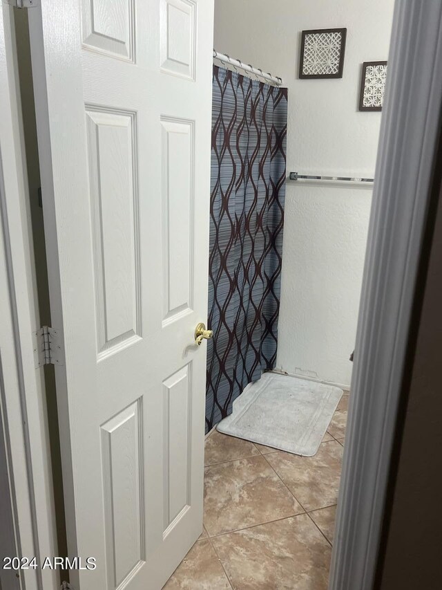 bathroom featuring curtained shower and tile patterned floors