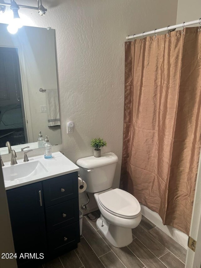 bathroom featuring vanity, toilet, a shower with curtain, and hardwood / wood-style floors