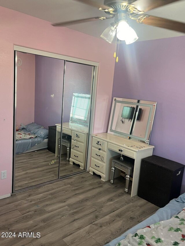 bedroom with ceiling fan, a closet, and dark hardwood / wood-style flooring