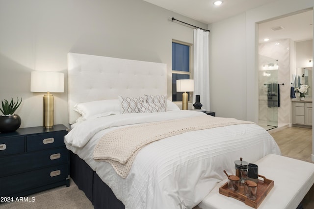 bedroom with recessed lighting, ensuite bath, and light wood-style floors