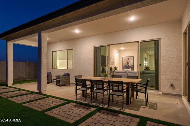 patio at twilight featuring fence and outdoor dining space