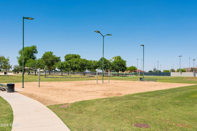 view of property's community featuring volleyball court, a lawn, and fence
