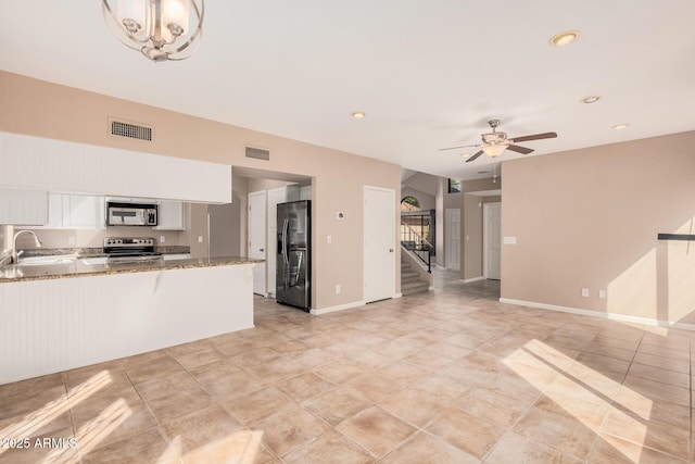 unfurnished living room featuring baseboards, a ceiling fan, visible vents, and a sink