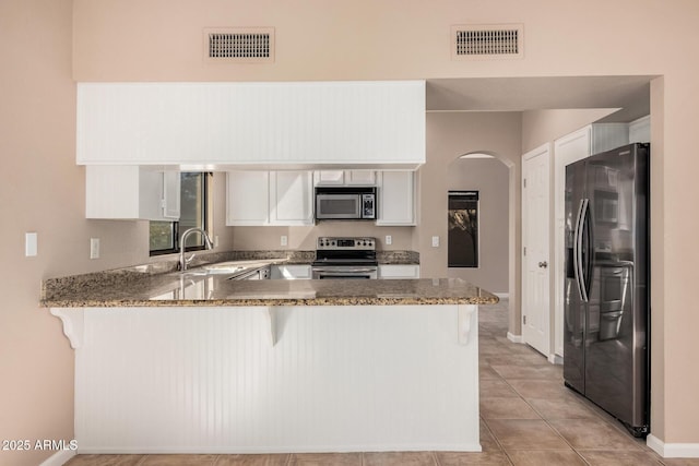 kitchen featuring a sink, visible vents, appliances with stainless steel finishes, and a peninsula