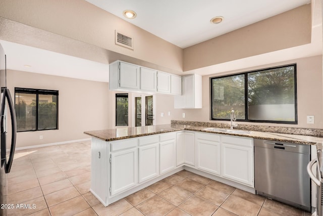 kitchen featuring visible vents, stone counters, a sink, white cabinets, and dishwasher