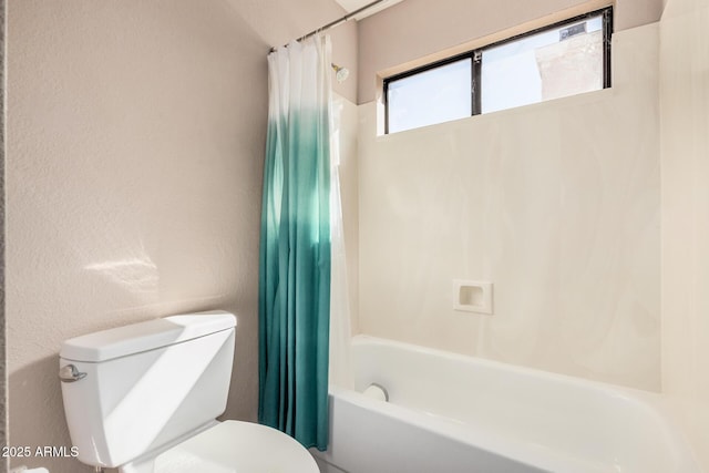 full bathroom featuring toilet, shower / tub combo with curtain, and a textured wall