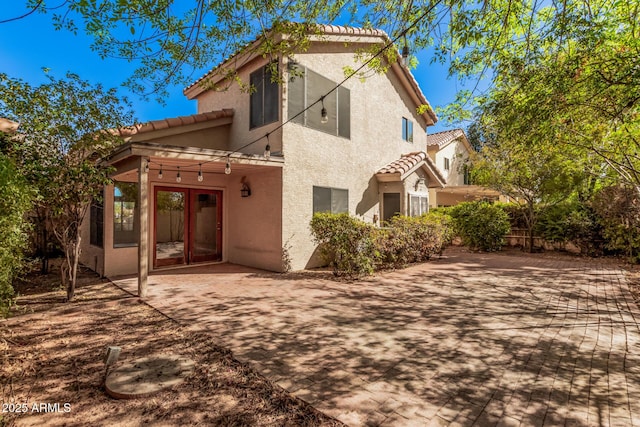 back of house with a patio, a tiled roof, and stucco siding