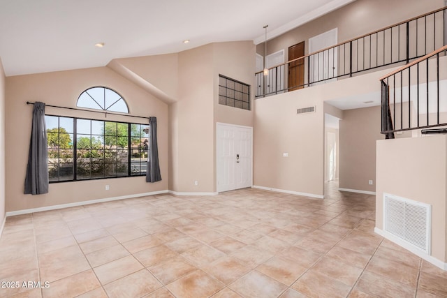 unfurnished room featuring light tile patterned floors, visible vents, baseboards, and high vaulted ceiling