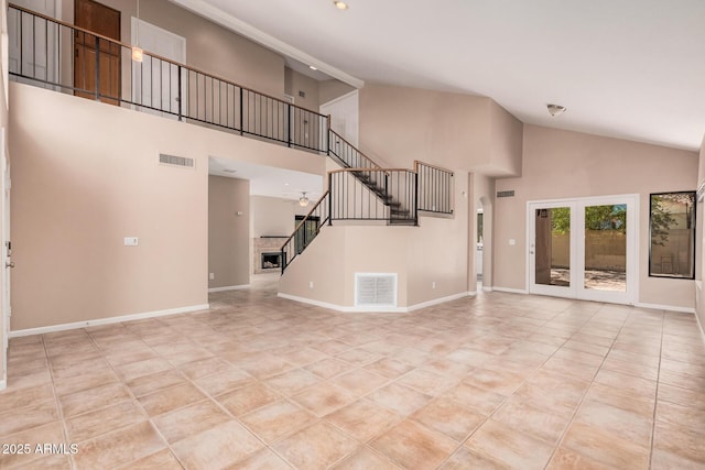 unfurnished living room featuring visible vents, baseboards, and stairs