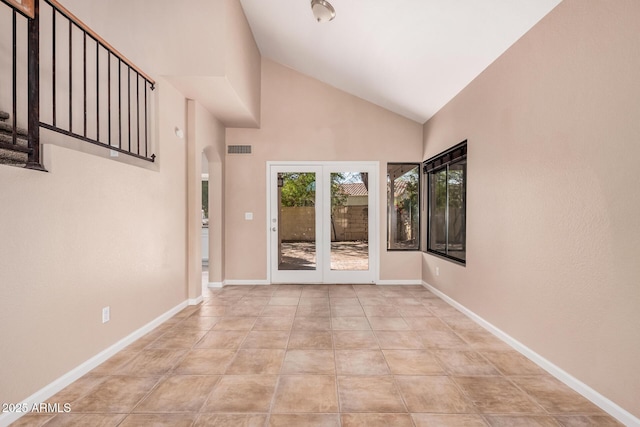 interior space with visible vents, arched walkways, high vaulted ceiling, and baseboards