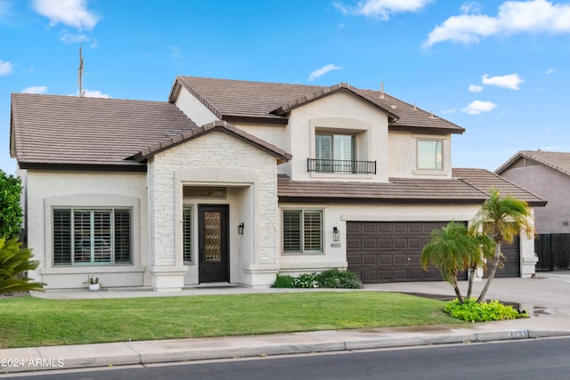 view of front of house with a balcony, a garage, and a front lawn