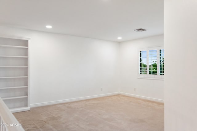 unfurnished room featuring light colored carpet