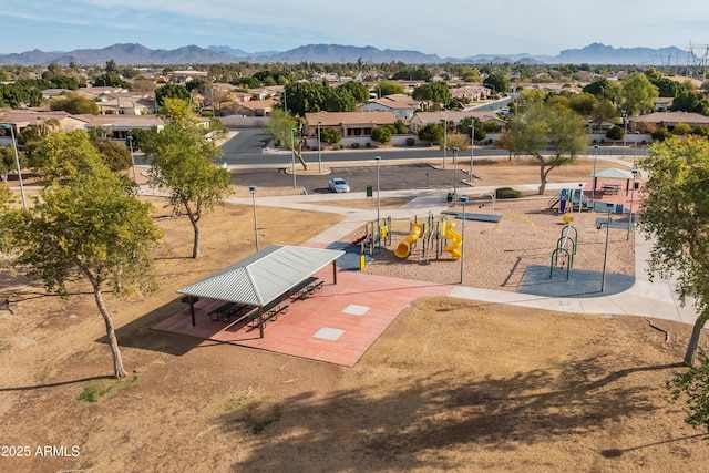 surrounding community with a playground and a mountain view