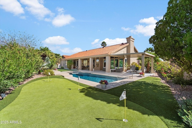 back of house featuring an outdoor pool, a patio, a chimney, a tiled roof, and stucco siding