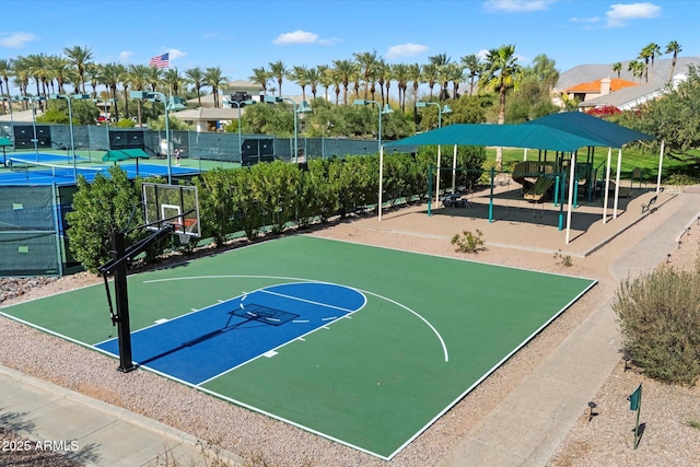 view of basketball court with community basketball court, playground community, and fence