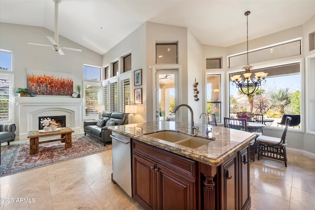 kitchen featuring plenty of natural light, a sink, a lit fireplace, and dishwasher