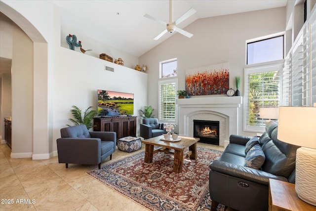 living area featuring high vaulted ceiling, visible vents, plenty of natural light, and a ceiling fan