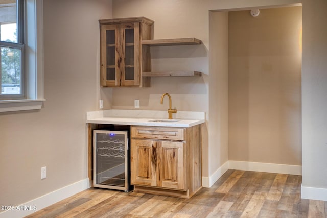 bar with sink, wine cooler, and light hardwood / wood-style flooring