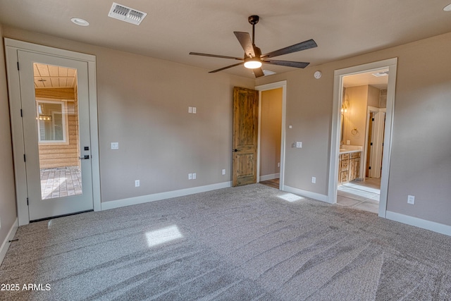 interior space with ceiling fan, ensuite bathroom, and light carpet