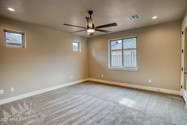 carpeted empty room featuring ceiling fan and plenty of natural light