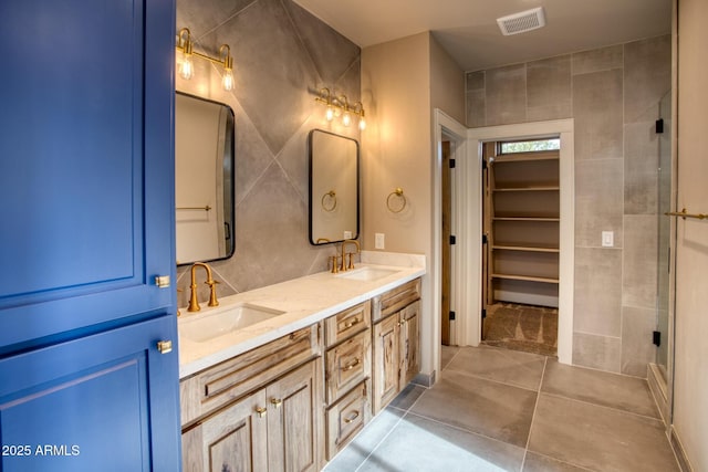 bathroom featuring vanity, tile patterned floors, and a shower with shower door