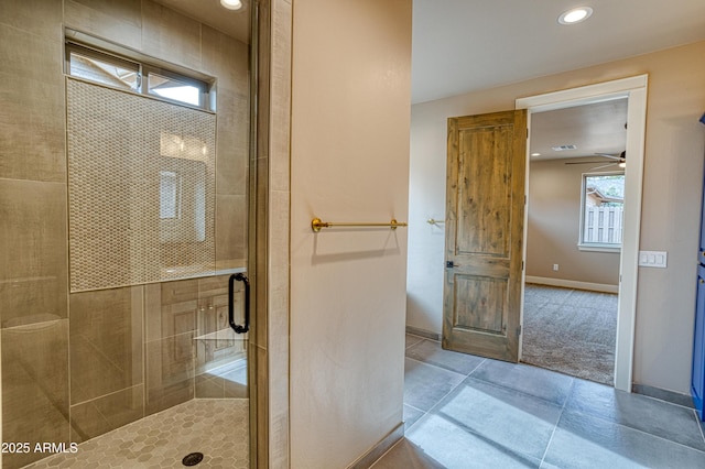 bathroom featuring ceiling fan and a shower with shower door