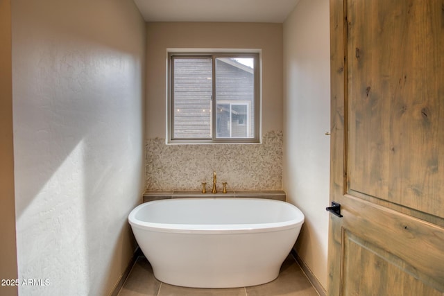 bathroom with tile patterned floors and a tub