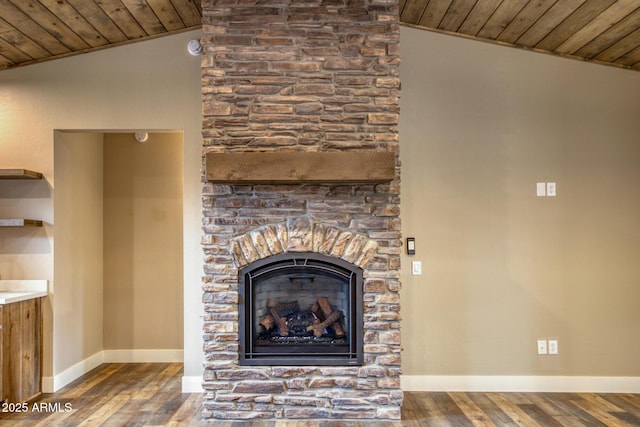 interior details featuring a stone fireplace, wood-type flooring, and wooden ceiling