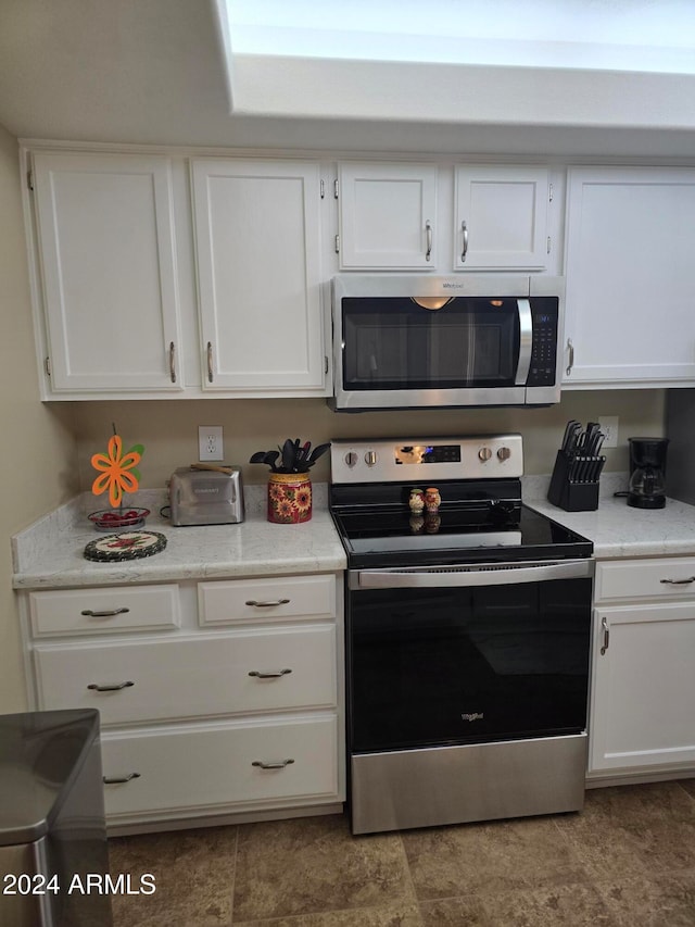 kitchen with white cabinets and appliances with stainless steel finishes