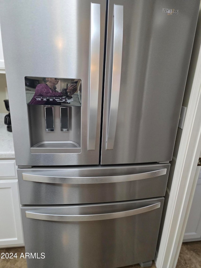 details featuring stainless steel fridge with ice dispenser and white cabinetry