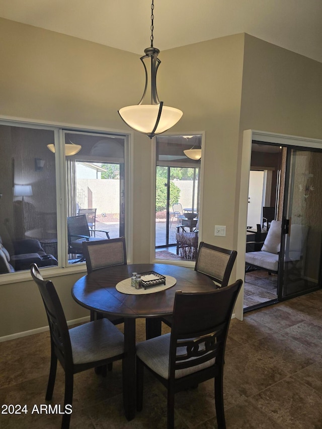 dining room featuring dark tile patterned floors and lofted ceiling