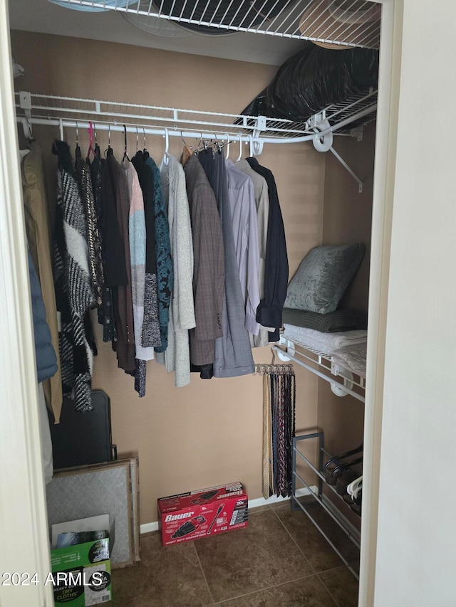 walk in closet featuring dark tile patterned floors