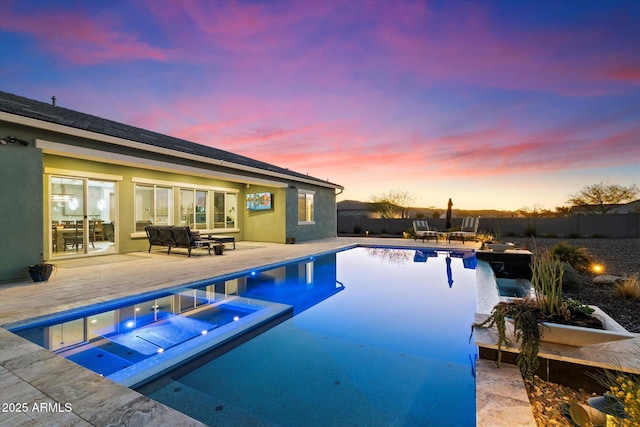 pool at dusk with a hot tub, an outdoor living space, and a patio