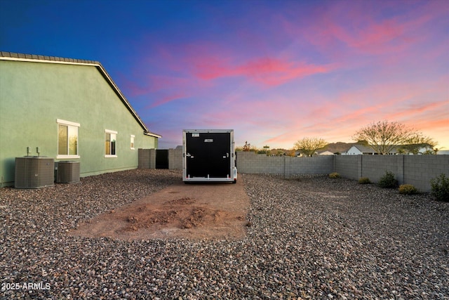 yard at dusk with central AC unit