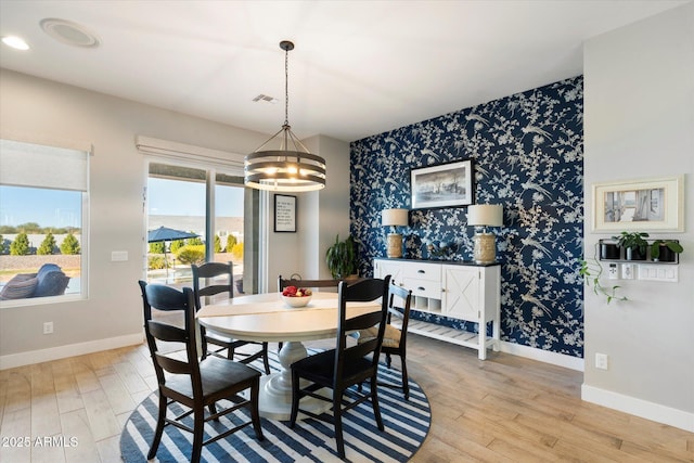 dining room with light hardwood / wood-style flooring and a notable chandelier