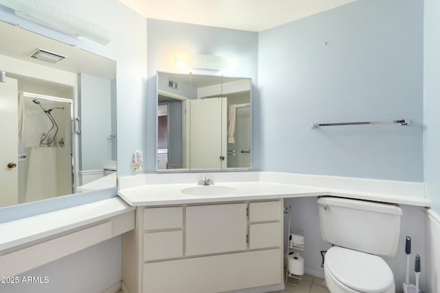 bathroom featuring a shower with shower door, vanity, tile patterned floors, and toilet