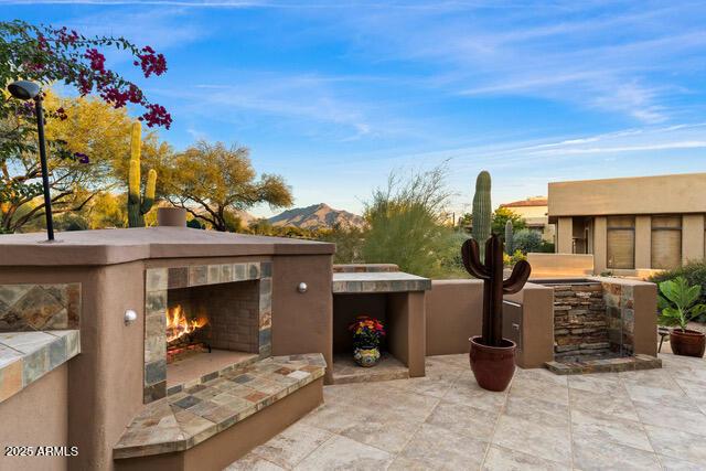 view of patio featuring a mountain view and exterior fireplace