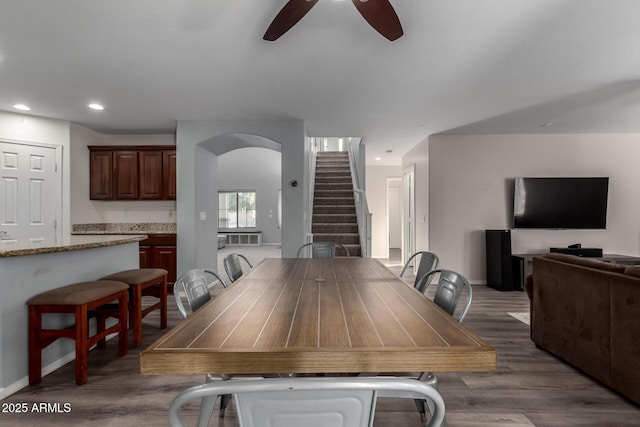 dining space with ceiling fan and dark wood-type flooring