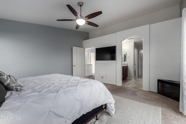 carpeted bedroom featuring ensuite bathroom and ceiling fan