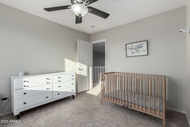 bedroom featuring a nursery area, ceiling fan, and carpet flooring