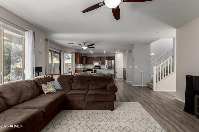 living room with wood-type flooring and ceiling fan