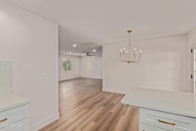 unfurnished dining area with a notable chandelier, light wood finished floors, baseboards, visible vents, and recessed lighting