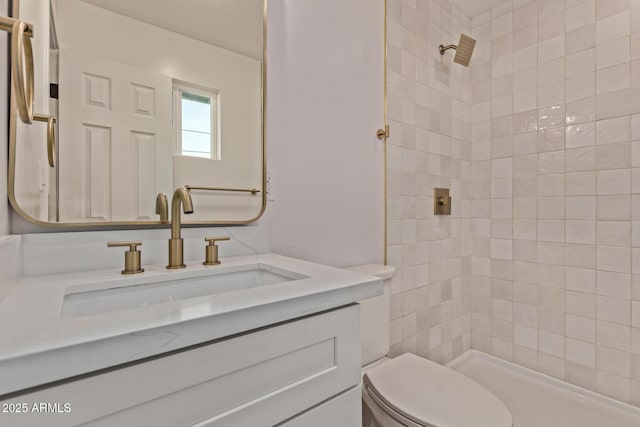 full bathroom featuring toilet, vanity, and a tile shower
