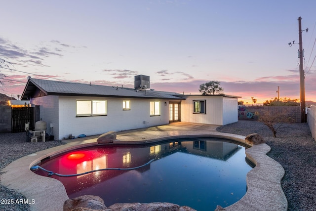 pool at dusk with a fenced backyard, grilling area, a patio area, and a fenced in pool
