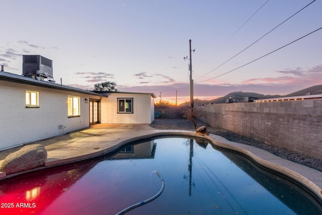 view of pool featuring central air condition unit, a fenced backyard, a fenced in pool, and a patio area