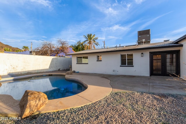 view of pool with fence, a fenced in pool, central AC, french doors, and a patio area