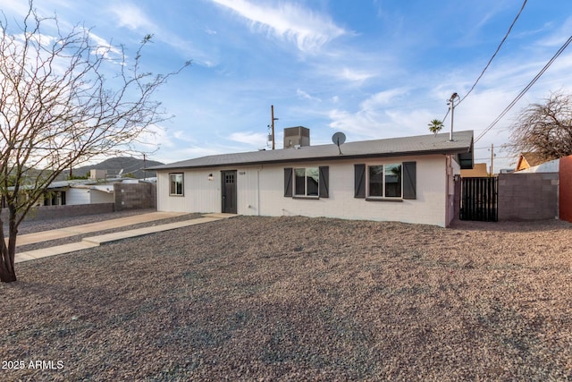 view of front of house featuring a gate, fence, and concrete block siding