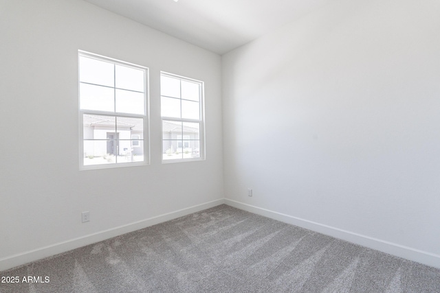 spare room with baseboards and carpet floors